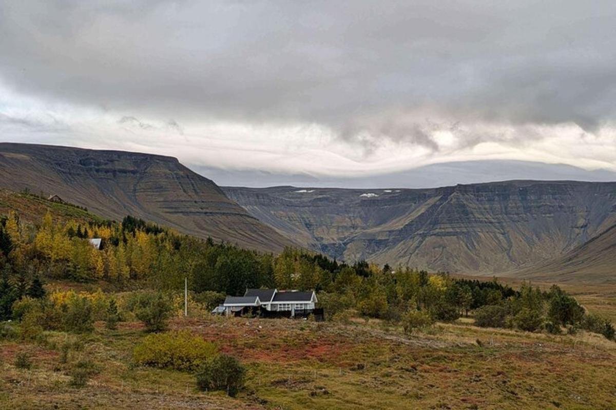 una casa en medio de un campo con montañas