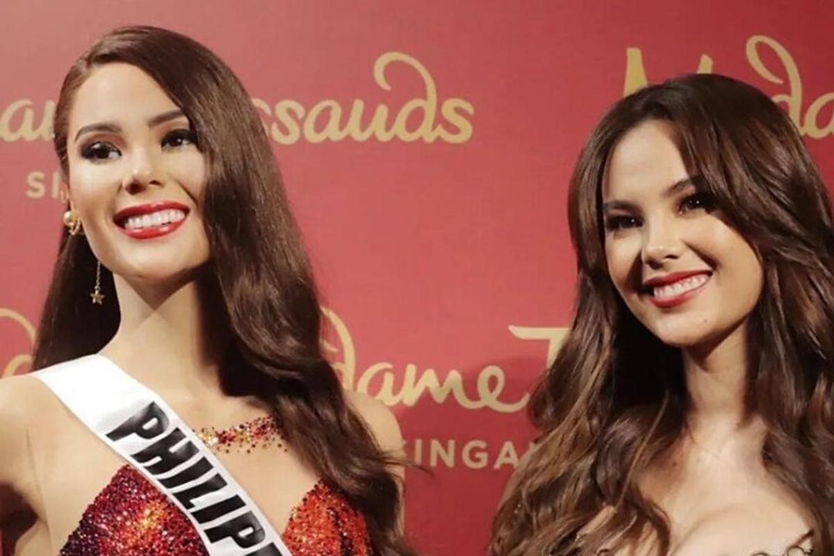 dua wanita berdiri di hadapan dinding merah