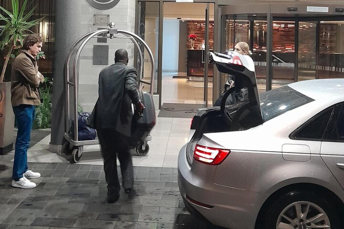 Un hombre con traje se sube a un coche.