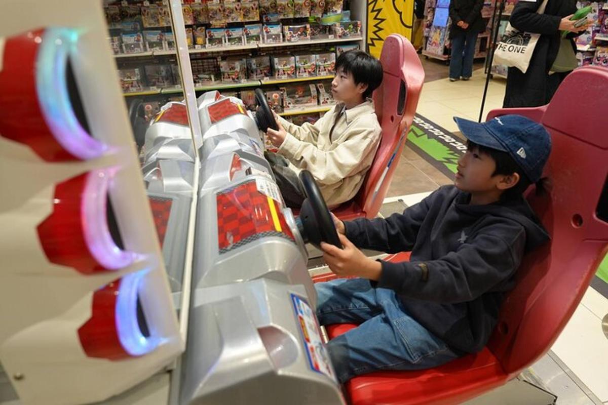 dua budak lelaki duduk di dalam kereta mainan di sebuah kedai