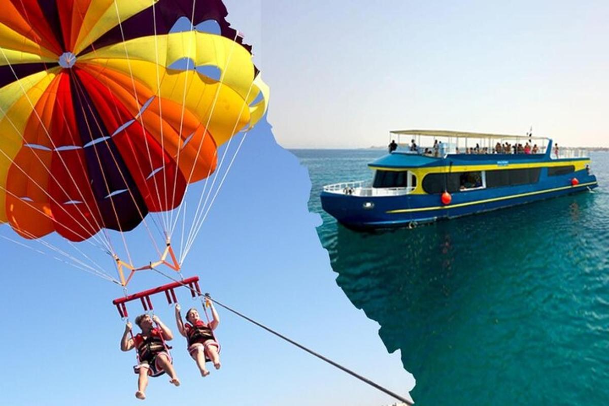 a group of people riding a parachute over the water with a boat