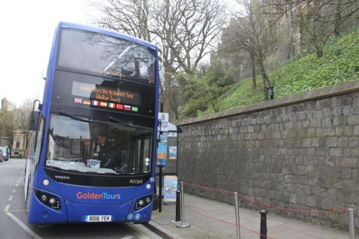 un autobus blu a due piani parcheggiato accanto a un muro