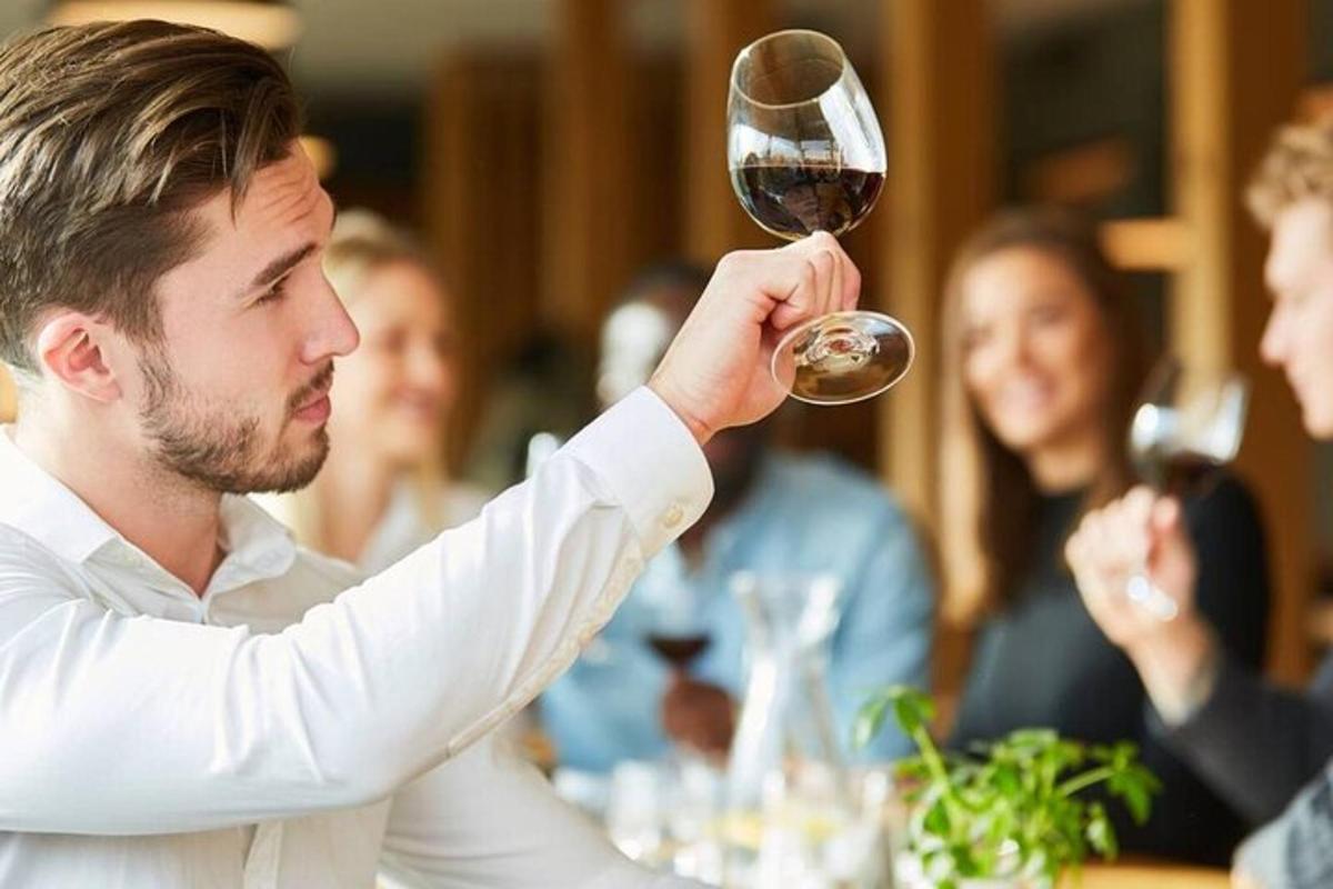 ein Mann hält ein Glas Wein hoch