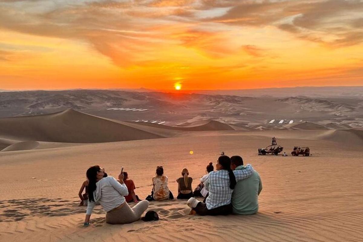 un gruppo di persone sedute nel deserto a guardare il tramonto