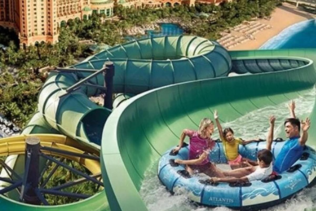 a group of people riding a water slide at a water park