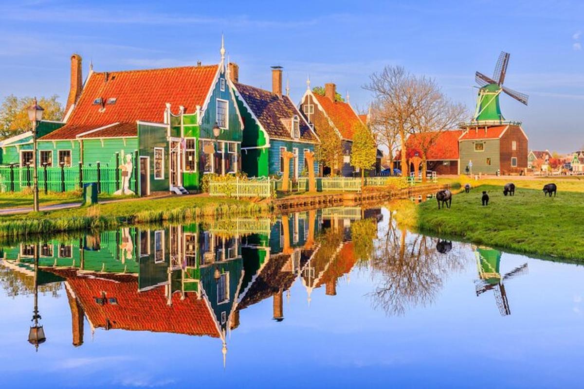 a group of houses and a windmill next to a body of water