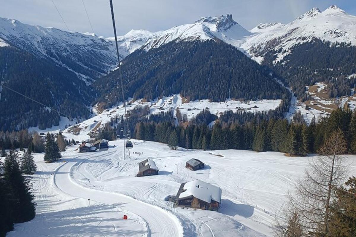a ski lodge on a ski slope with snow covered mountains