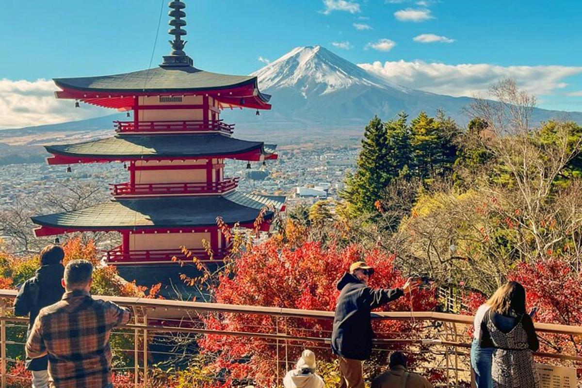 Un grupo de personas de pie alrededor de una pagoda frente a una montaña.