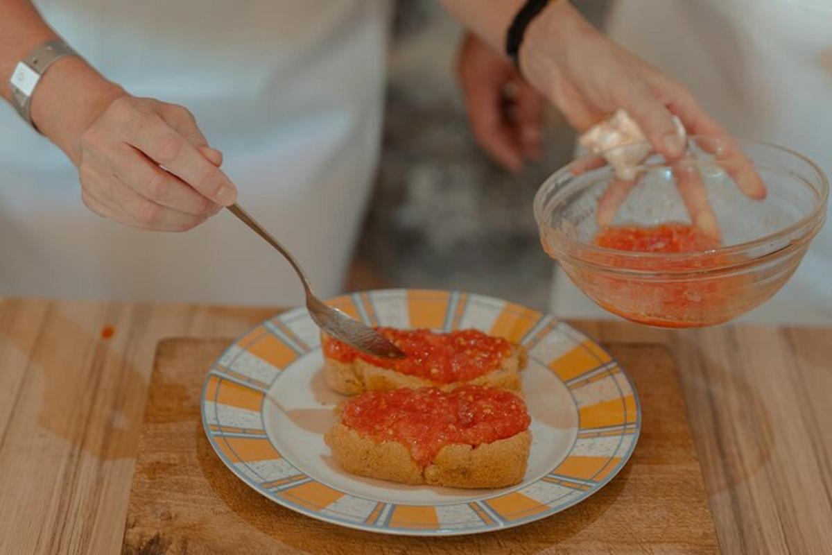una persona che spalma la salsa su un pezzo di pane su un piatto