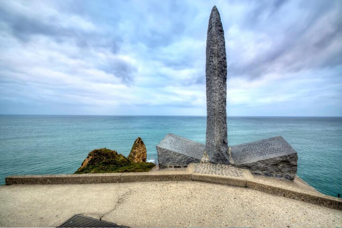 a statue on top of a wall near the ocean