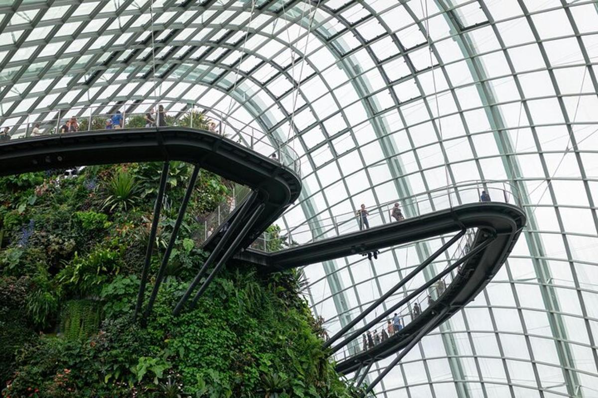 大きなガラスドームの建物のエスカレーターに乗っている人々