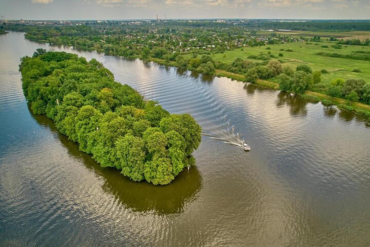 otok sredi reke s čolnom