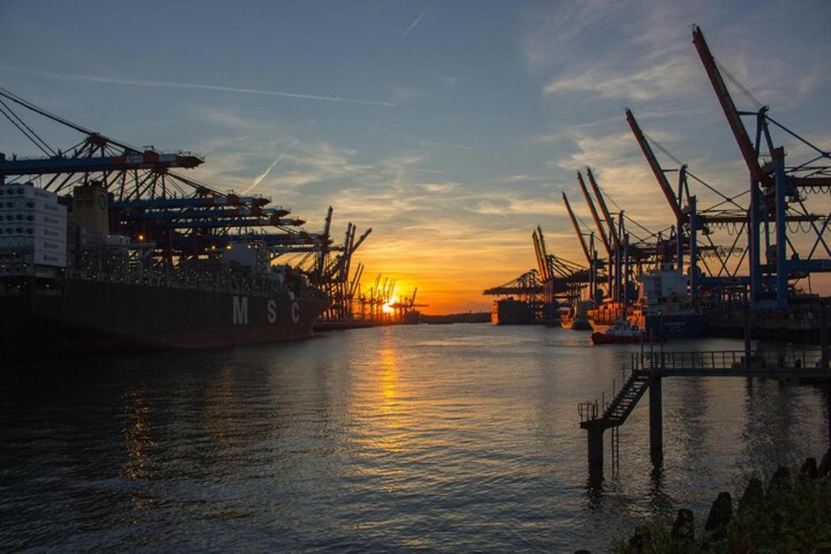 a large ship is docked at a dock with the sunset