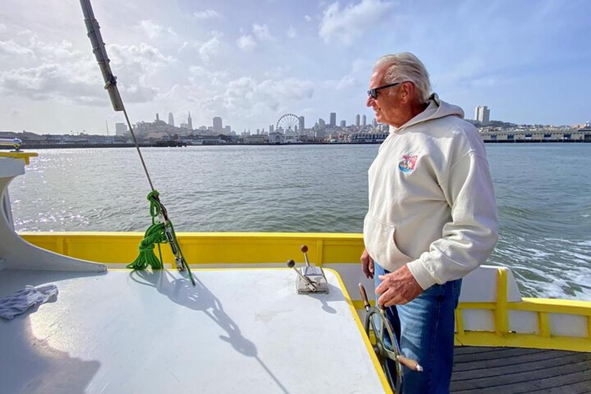 an older man standing on the deck of a boat
