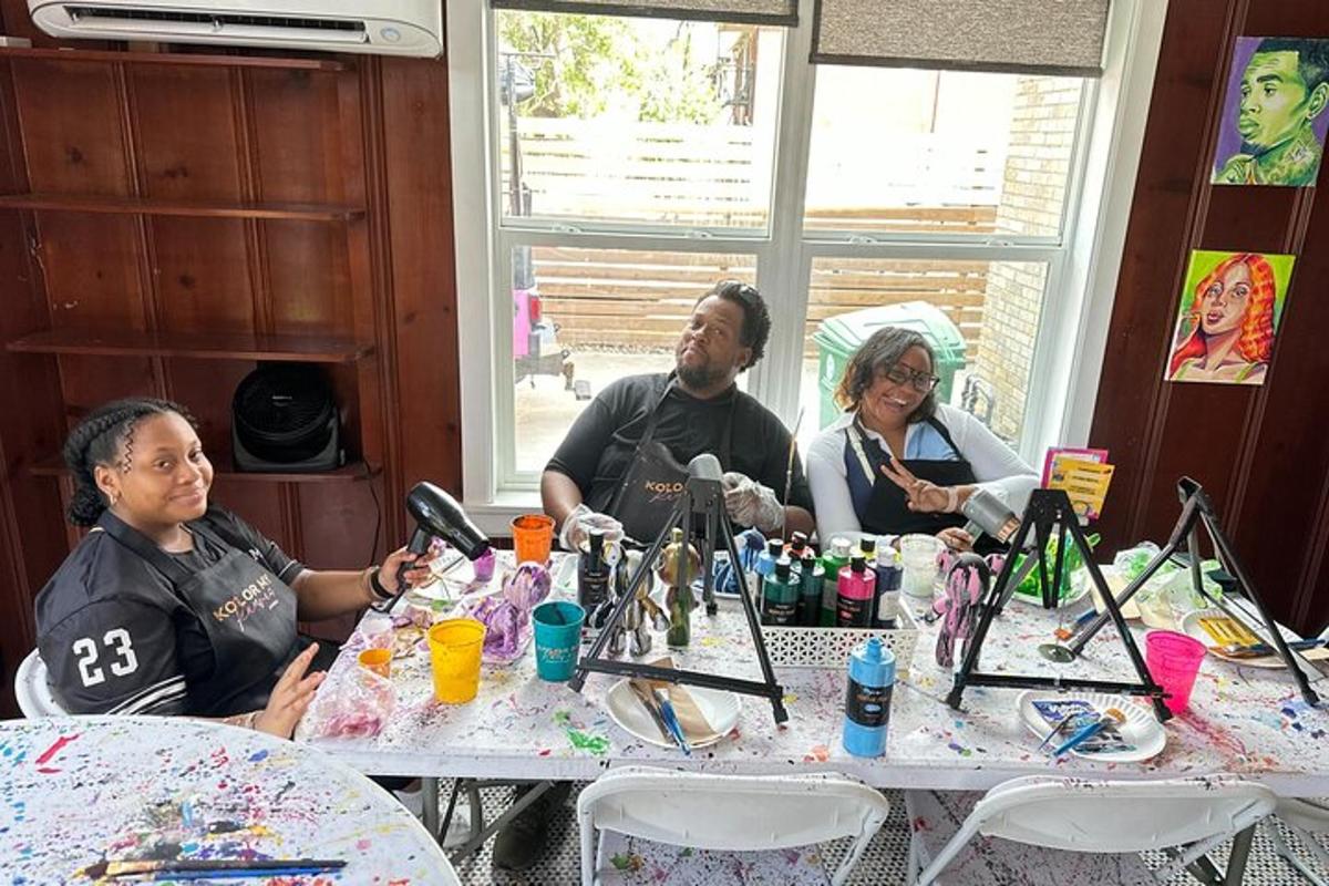 a group of people sitting at a table with paints