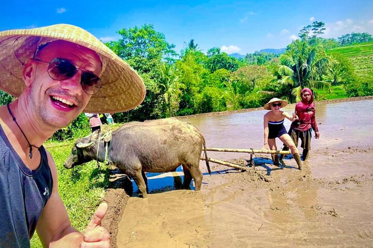 un uomo con un cappello di paglia sta trainando un bufalo d'acqua