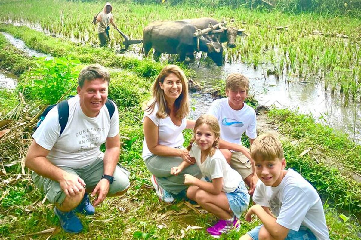 uma família posando para uma foto em frente a um elefante