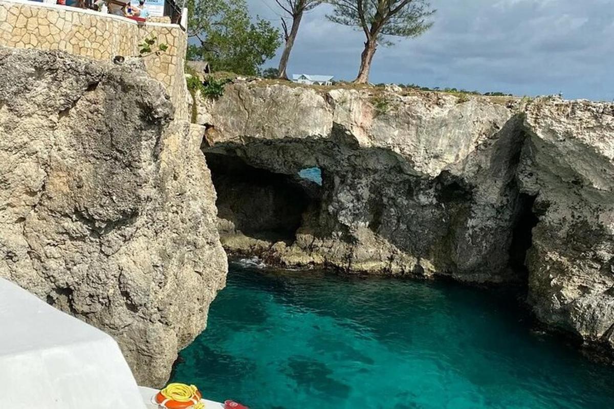 μια λίμνη με σμαραγδένιο πράσινο νερό δίπλα σε έναν βραχώδη γκρεμό