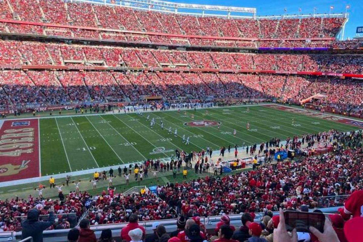 a crowd of people watching a football game in a stadium