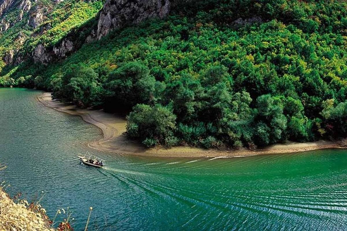 a boat in the water next to a small island