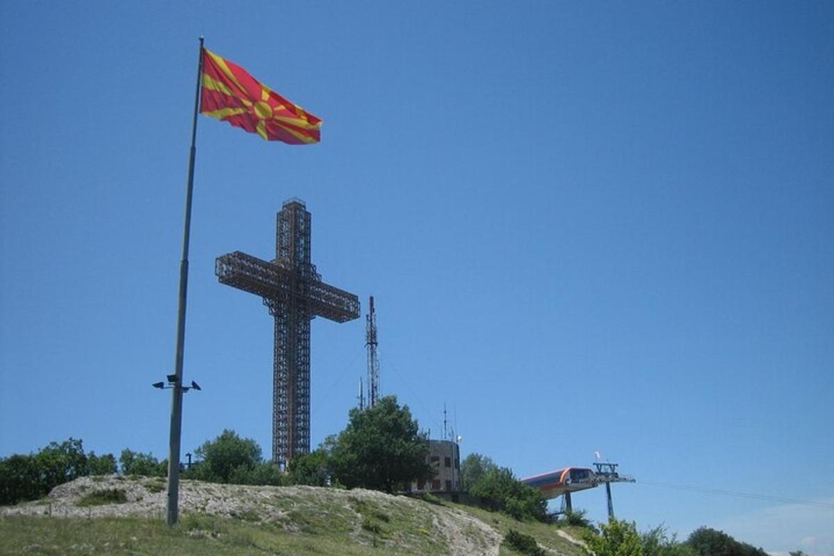 a flag on top of a hill next to a cross