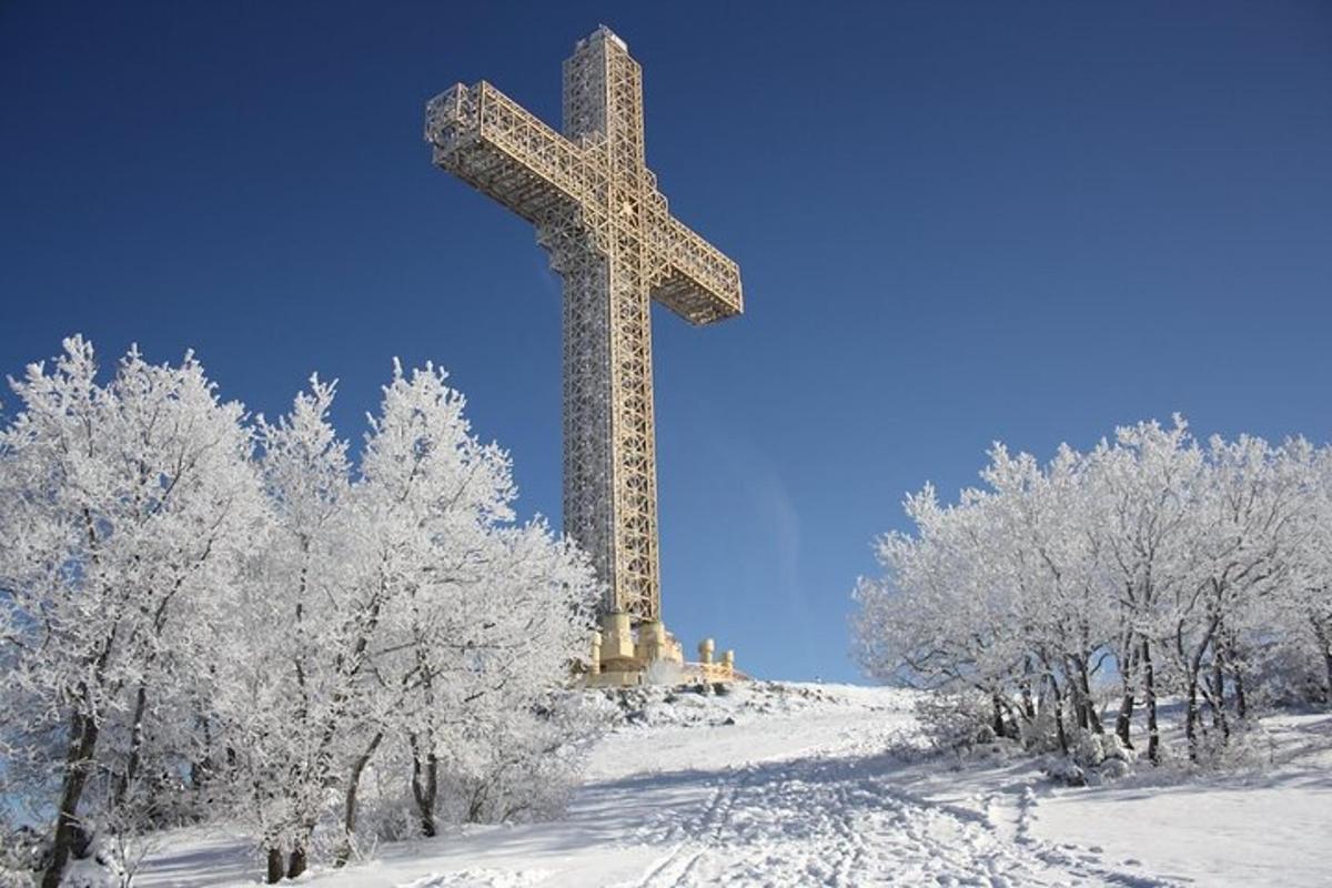 a cross on top of a snow covered hill