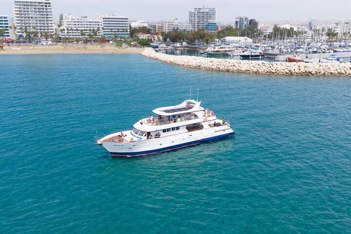 a white boat in the water near a beach