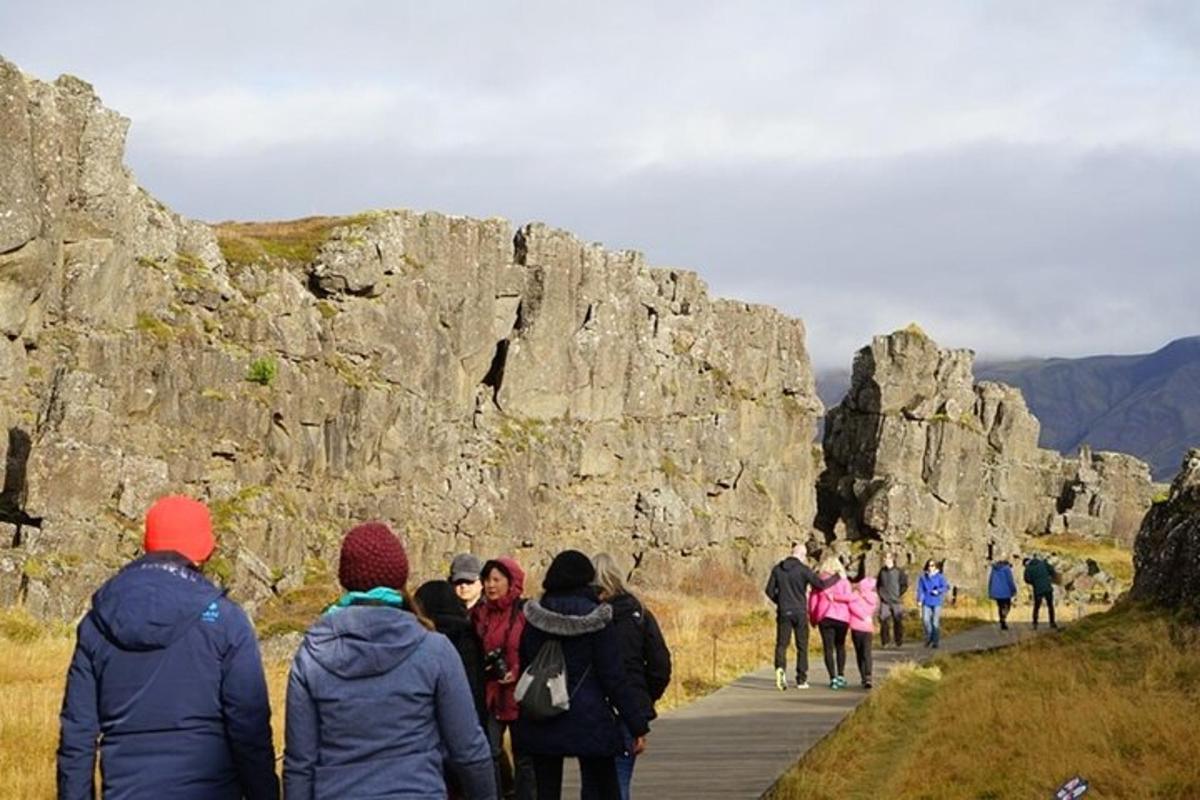 un gruppo di persone che cammina su un sentiero vicino ad alcune rocce