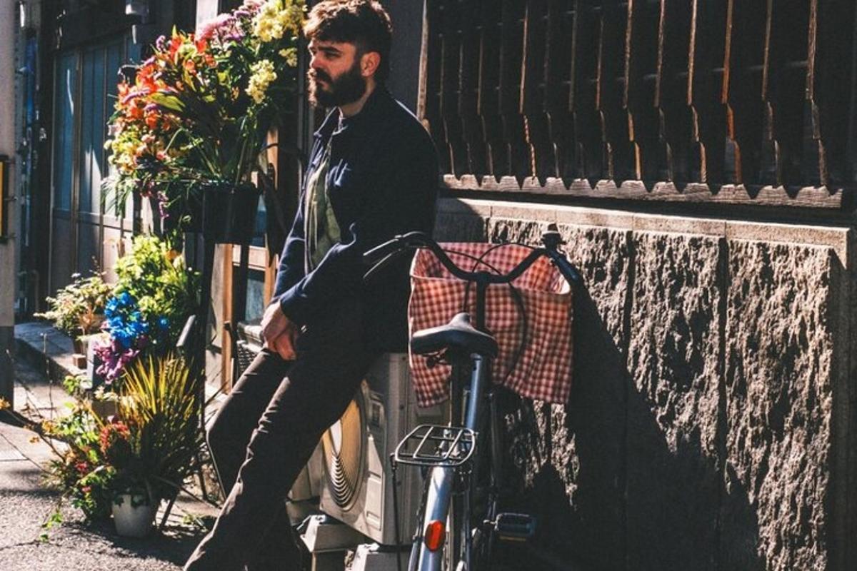 muž sediaci na stene vedľa bicykla