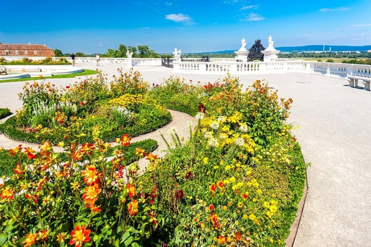Un jardín con flores de colores y una valla blanca.
