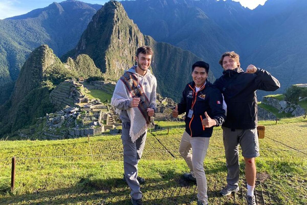 a group of three men standing on top of a mountain