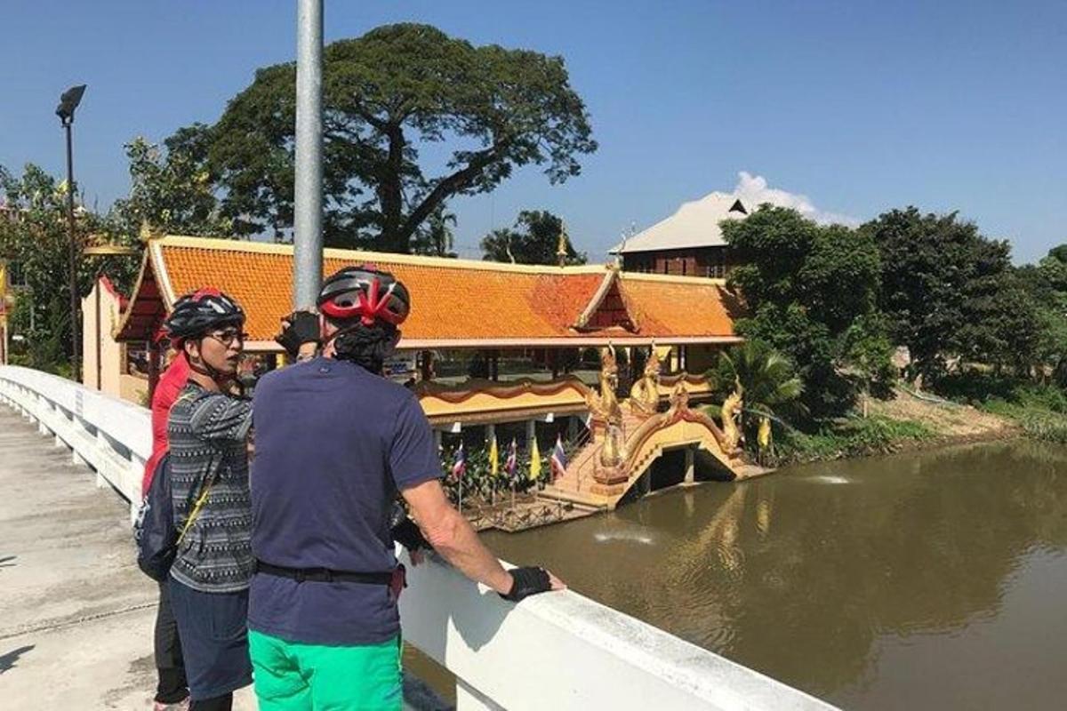 due persone in piedi su un ponte che guardano oltre un fiume
