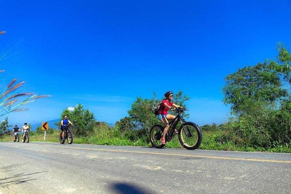 un gruppo di persone che vanno in bicicletta lungo una strada