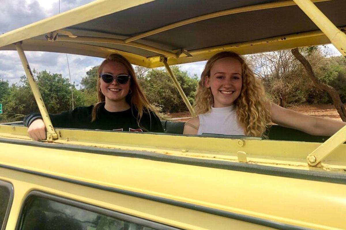 two girls are riding in a yellow truck