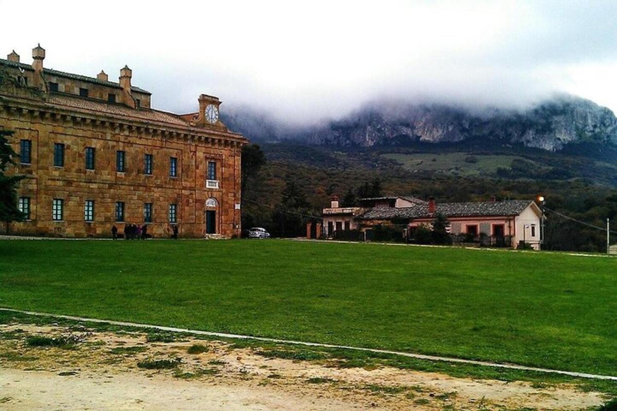 un grande edificio in mattoni con una montagna sullo sfondo