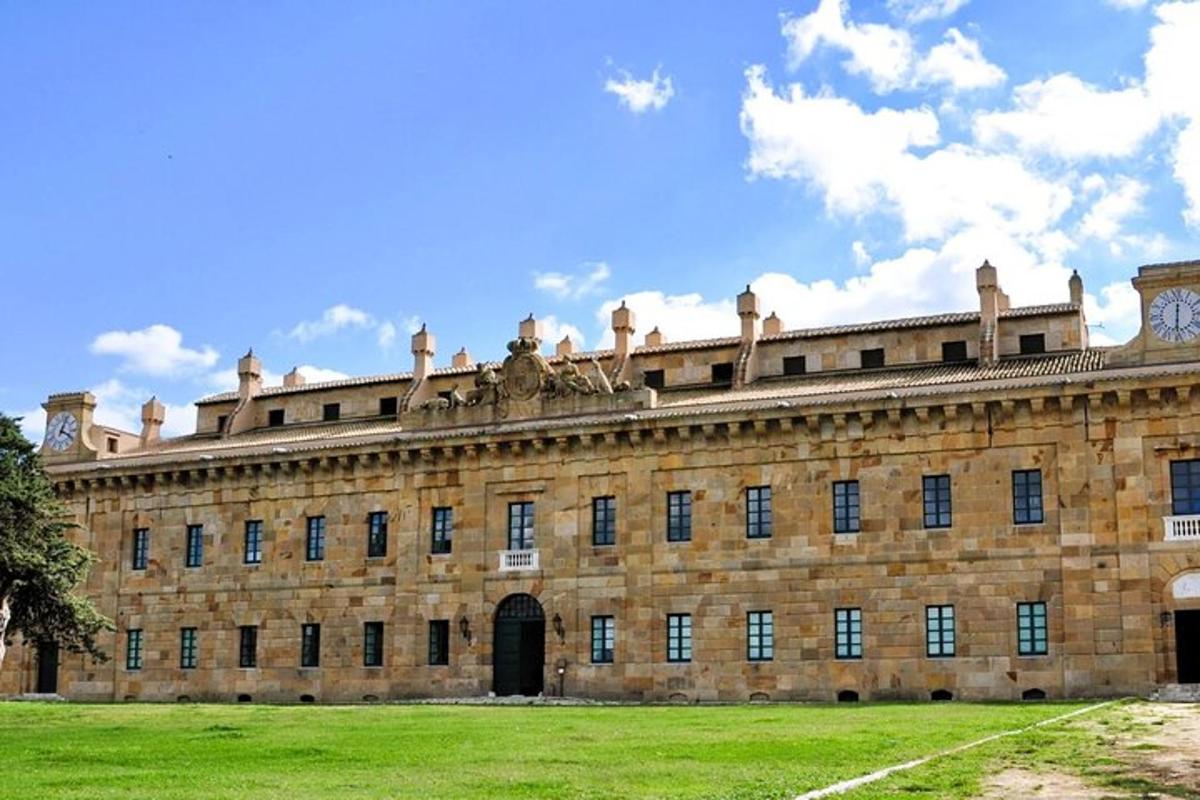 un grande edificio in mattoni con un campo erboso di fronte