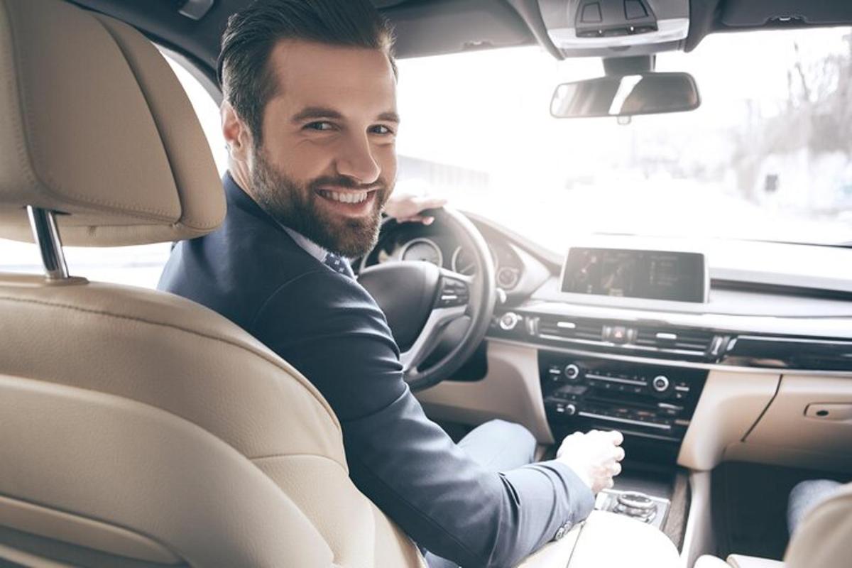 un uomo seduto al posto di guida di un'auto
