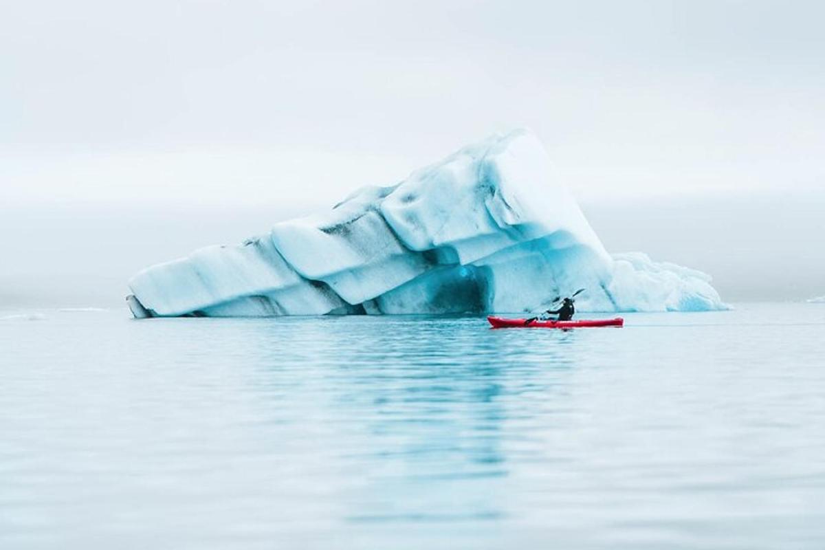 a person on a boat in front of an iceberg