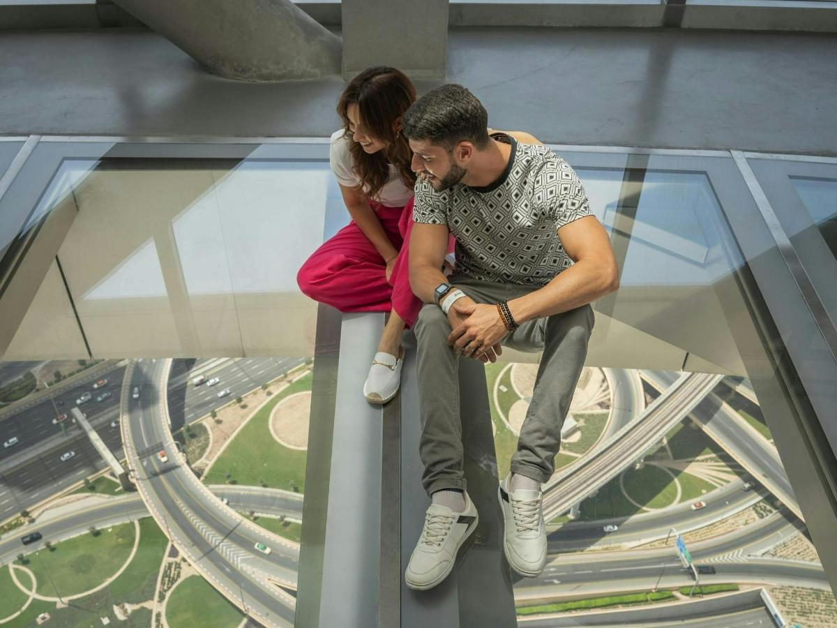 een man en een vrouw zitten bovenop een glazen toren