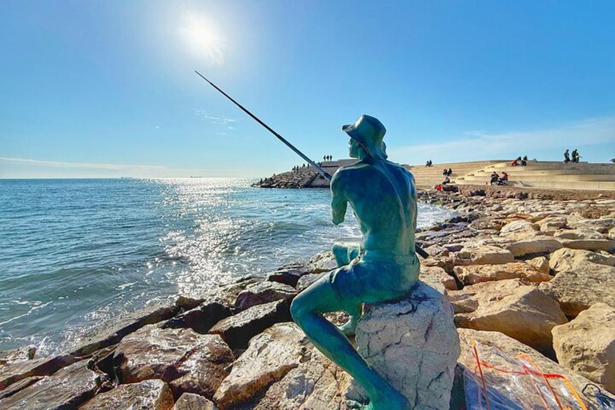 una statua di un uomo che pesca su una spiaggia