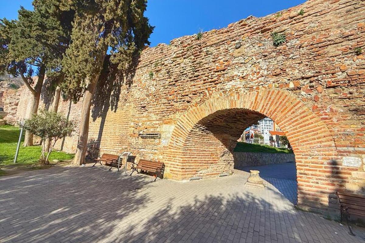 un muro di mattoni con due panchine sotto un ponte