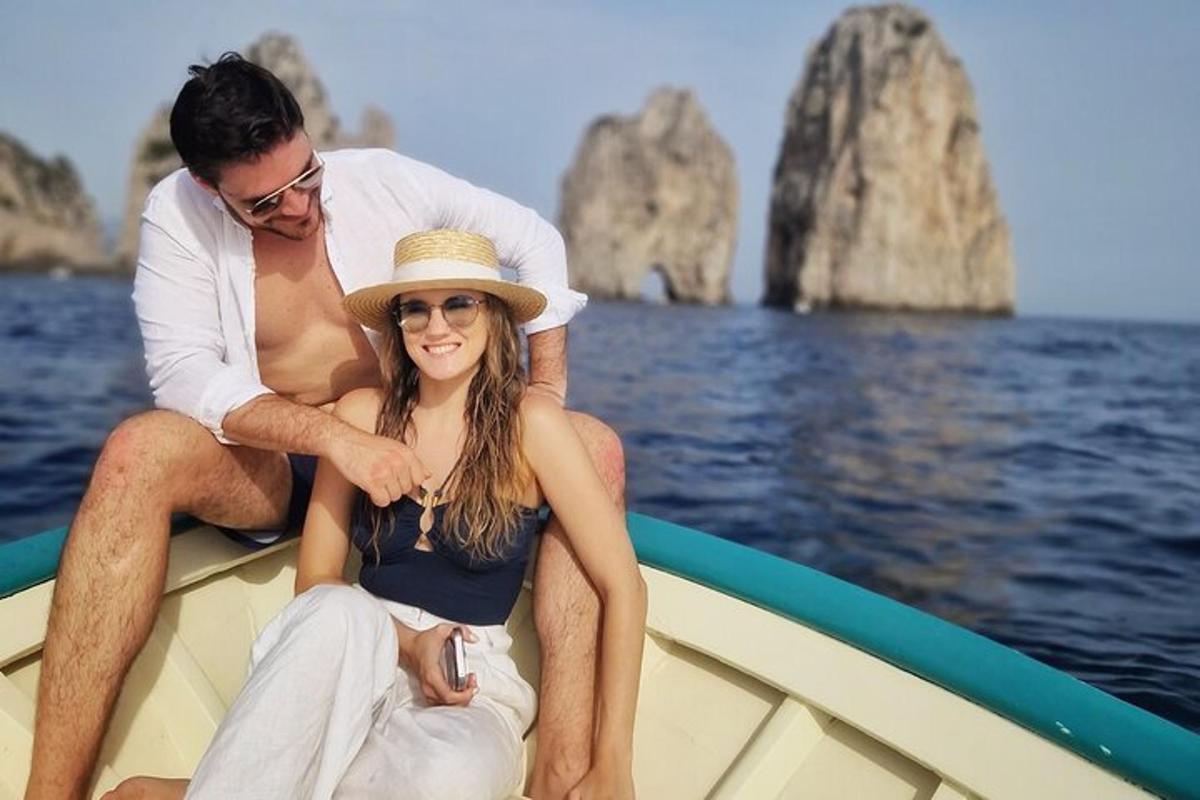 a man and woman sitting on a boat in the water
