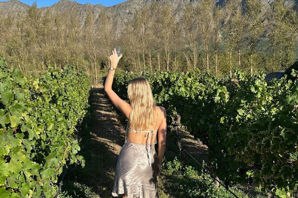 una donna in un vigneto che tiene la mano in aria