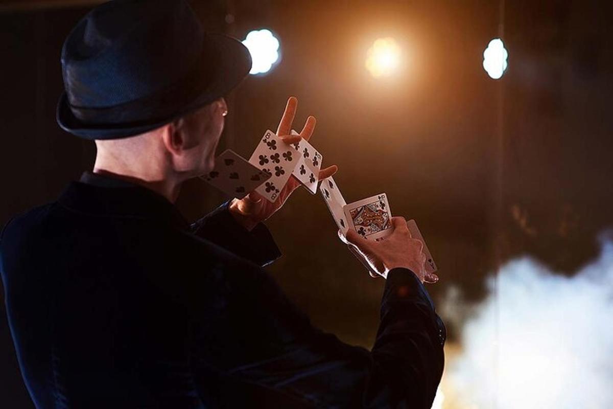 un uomo che tiene in mano un pezzo di carta e gioca a carte