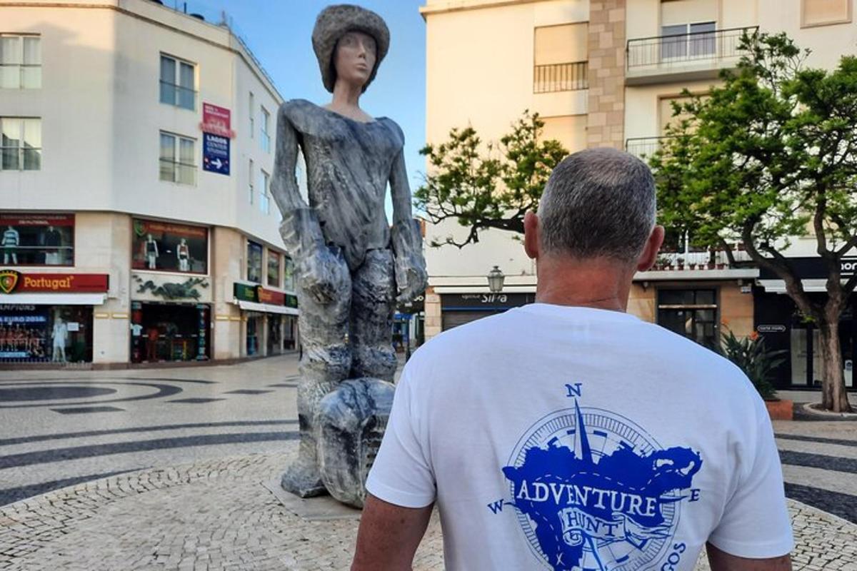 muž stojící vedle sochy na ulici