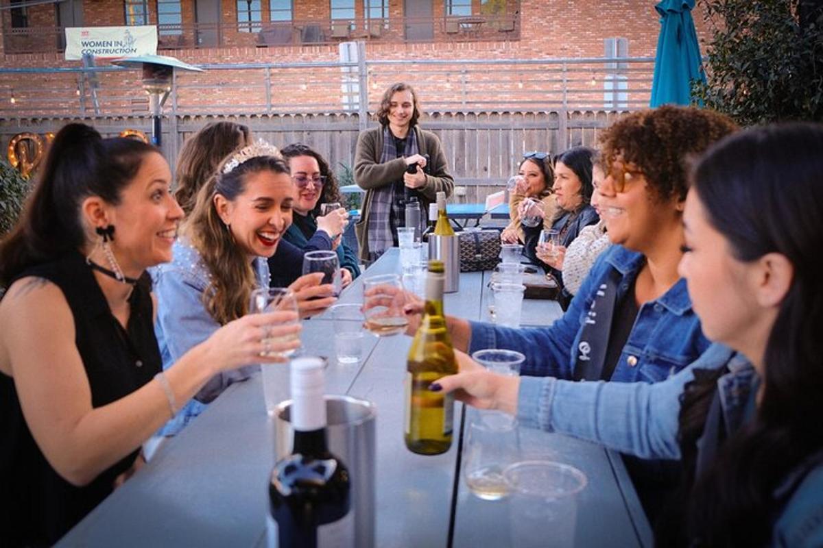 Un grupo de personas sentadas en una mesa con copas de vino.