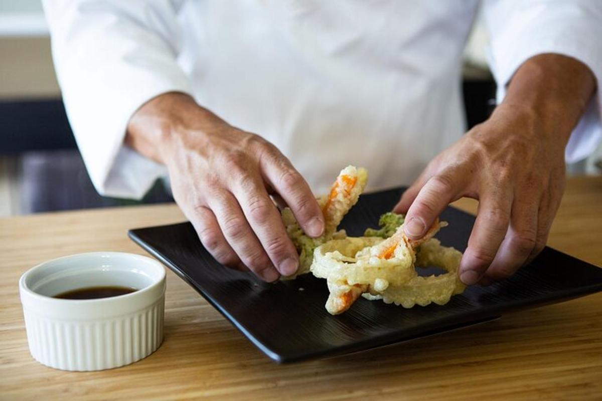 una persona que sosté un plat amb menjar a la taula