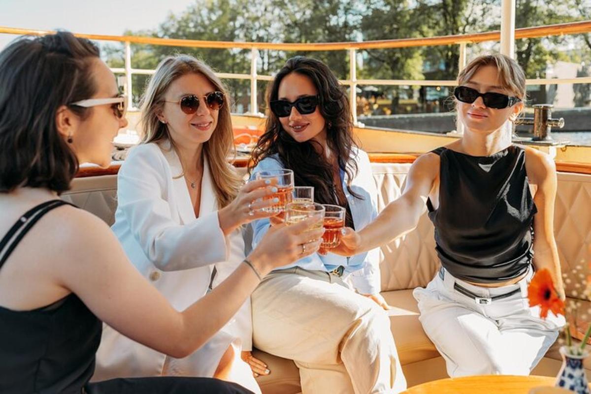 a group of women sitting on a boat drinking
