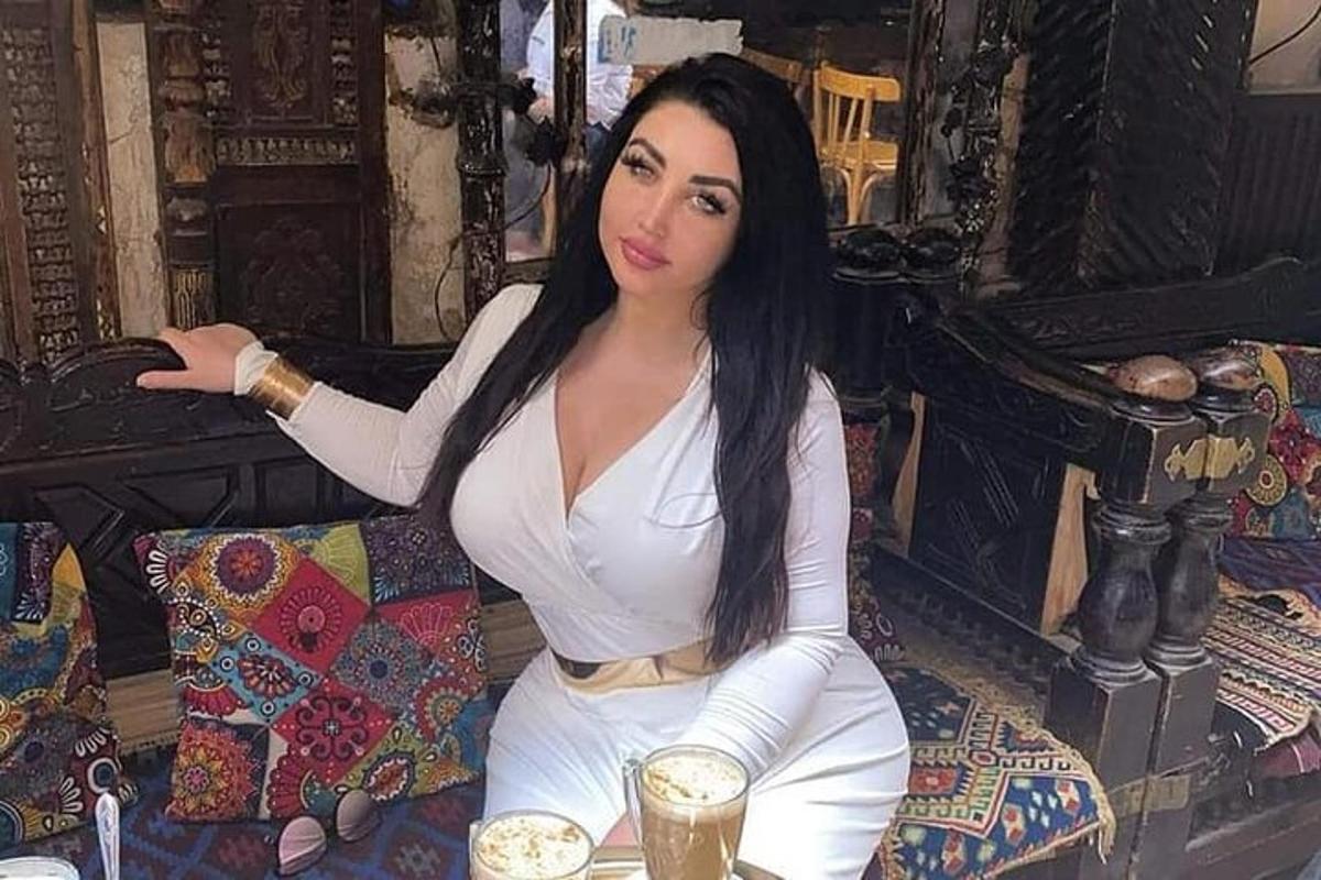 امرأة تجلس على الأريكة مع مشروب