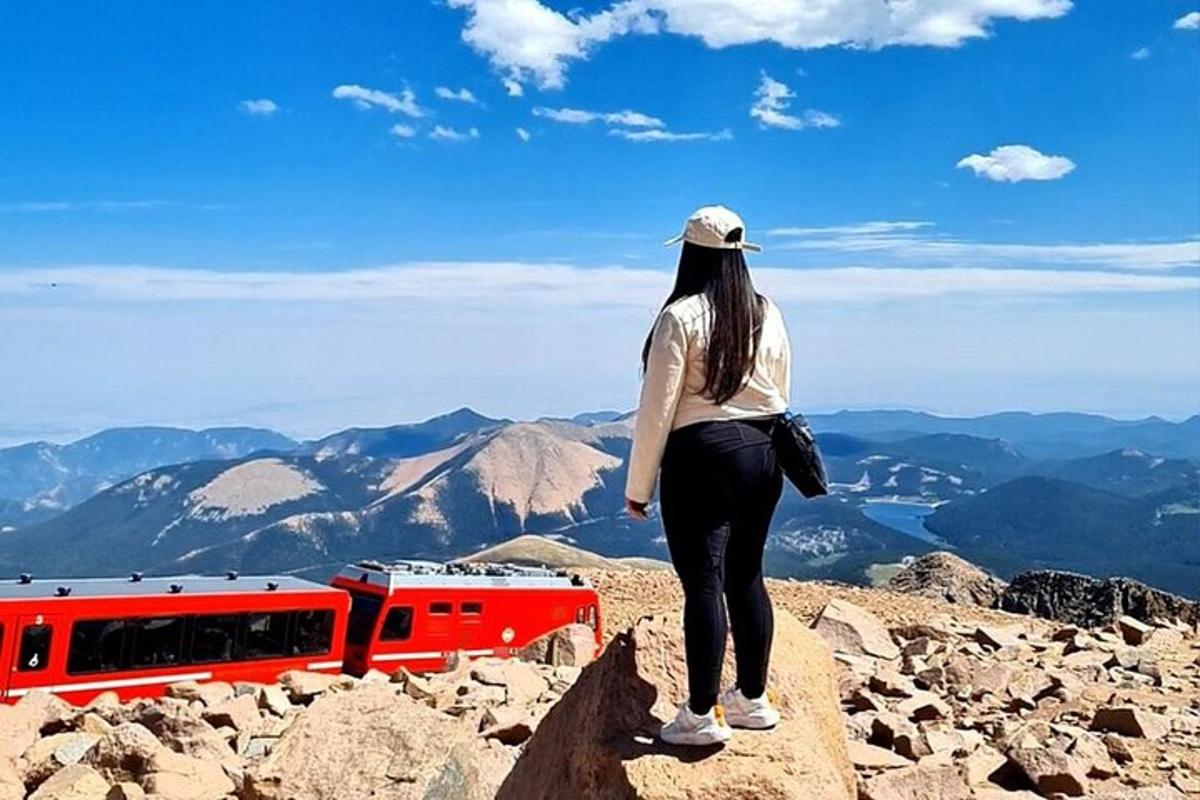 en kvinne som står på toppen av et fjell